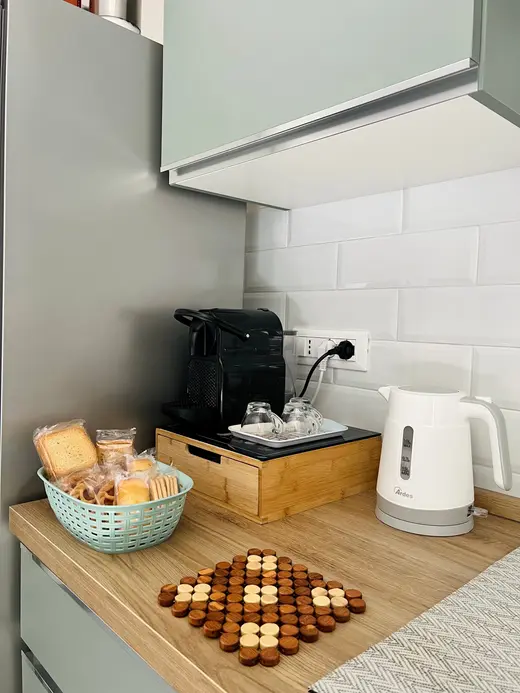 Angolo caffè con macchina a cialde, bollitore e cestino per la colazione