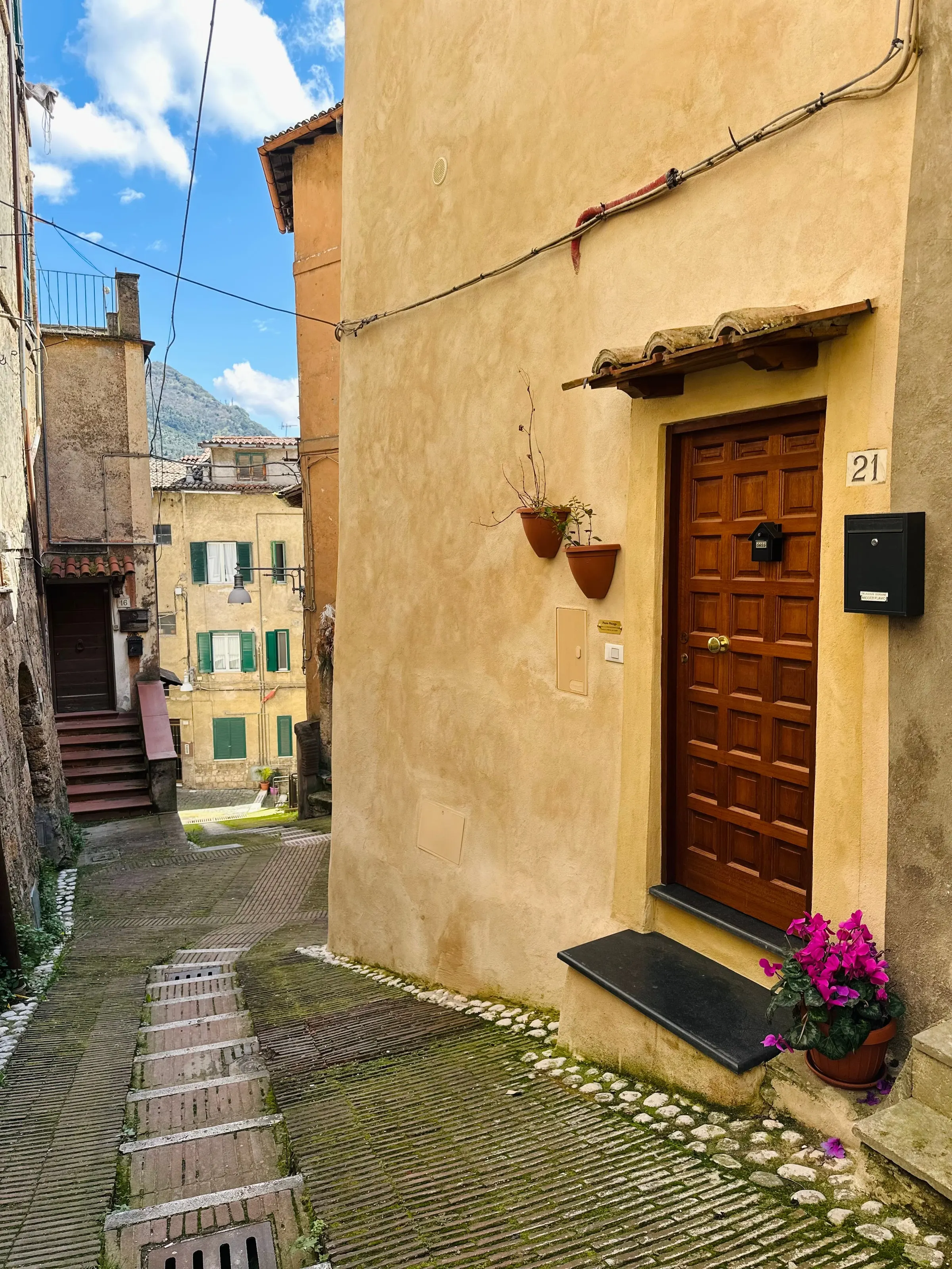 Il vicolo acciottolato del centro storico di Subiaco con la porta in legno de Il Rifugio nel Vicolo